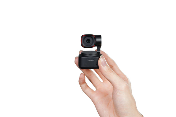 Black OBSBOT Tiny 2 shown at actual size next to a hand. – image 6