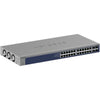 Front left view of Netgear XS724TM 24-port 10G managed network switch with multiple Ethernet ports and LED indicators.